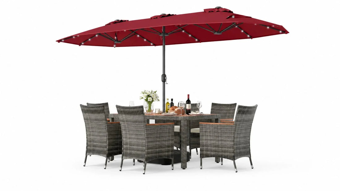Outdoor table decor with a gray wicker dining set, red patio umbrella, wine bottles, glasses, bread, and a floral centerpiece.